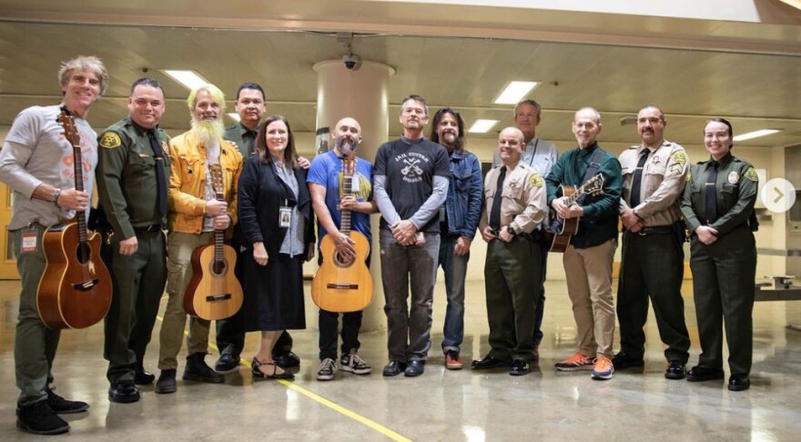 The organization Jail Guitar Doors, with Wayne Kramer (third from right), at Twin Towers Correctional Facility in Los Angeles, California, in March 2023. Not pictured, incarcerated participants who performed what they learned during a 12-week workshop and were awarded certificates of completion.