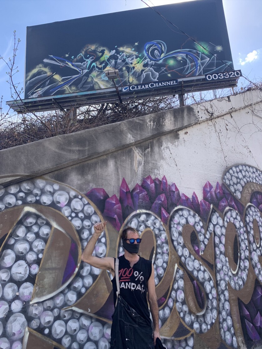 Joos under a billboard he hit with graffiti.