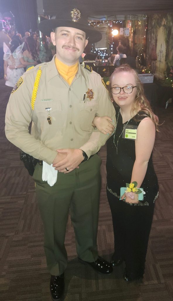Correctional officer poses for a photo at the special needs prom.