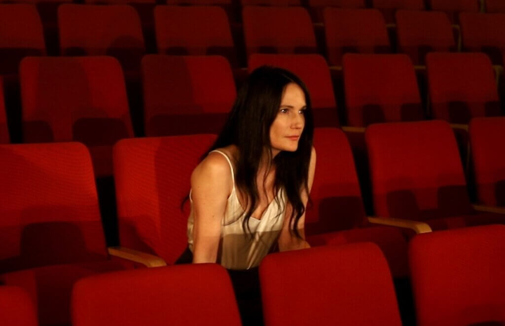 A photo of Einat Weizman sitting in a theater.
