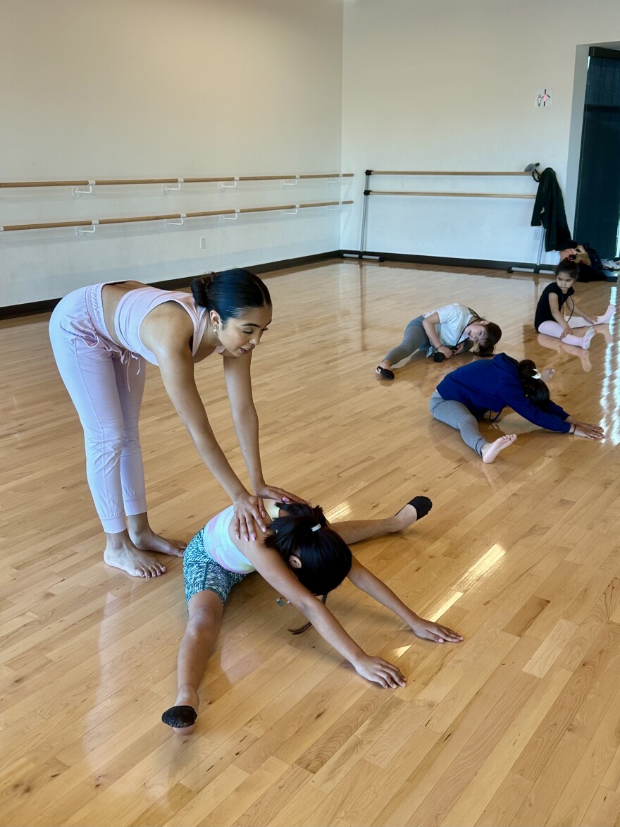 Cassie, helping one of her student with a split at the Dance Studio