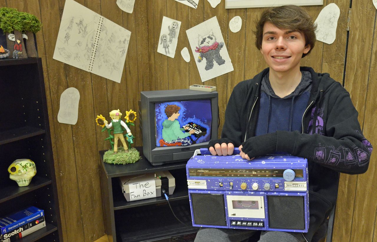 high school student showing his artwork