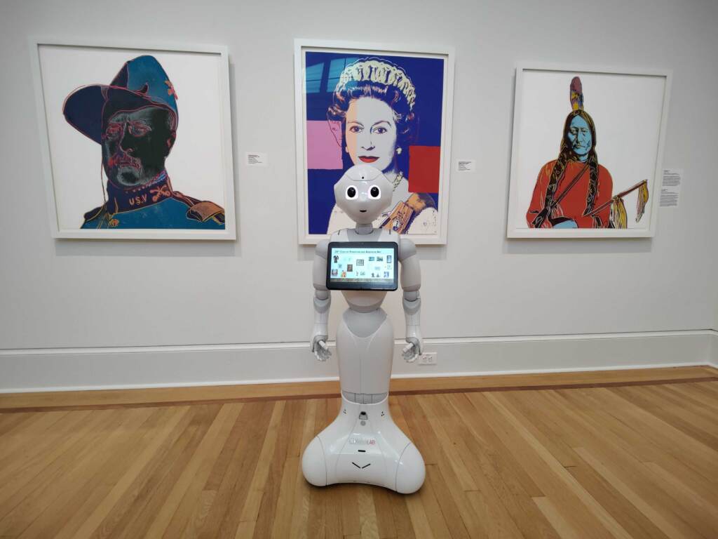 Pepper, a robot being programmed to be a gallery docent, can tell you about the Andy Warhol prints behind it at the Frances M. Maguire Art Museum