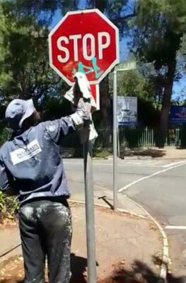 A man hired by the PRA cleans a stop sign