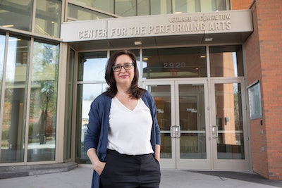 Dr. Laura L. Tesman stands in front of the Leonard & Claire Tow Center for the Performing Arts at Brooklyn College.