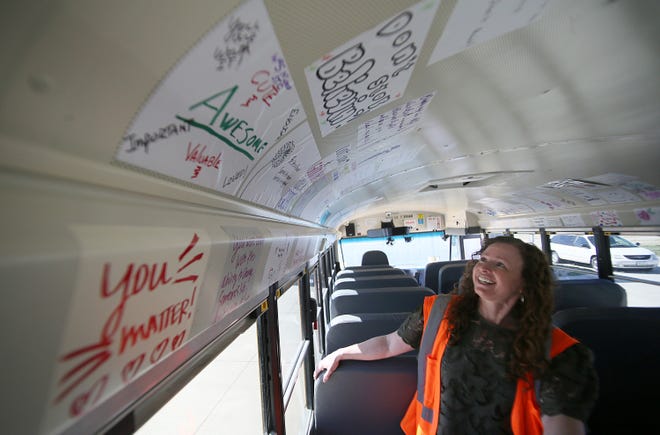 Sara Knight, general manager at Durham School Services, shows the positive graffiti displayed inside a school bus. The Graffiti Bus will be used one day on each route in the Ames school district and is intended to uplift and encourage students.