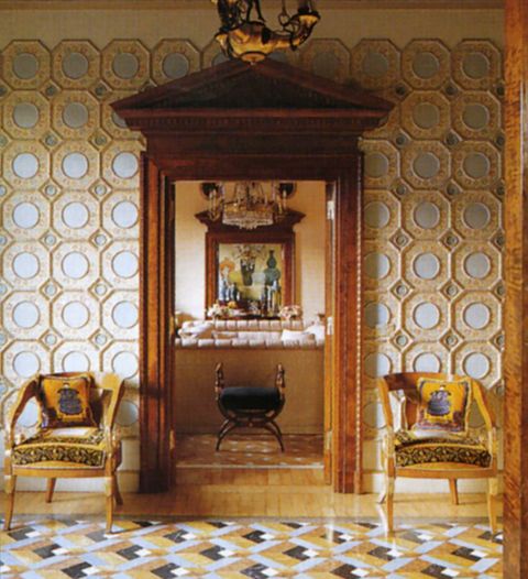 the trompe ooeil floor in the entrance hall is marble and the antique walnut chairs are french