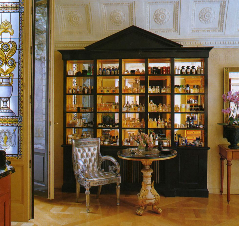 a mirror backed display case holds donatella versaces extensive collection of fragrances he pedestal is french empire