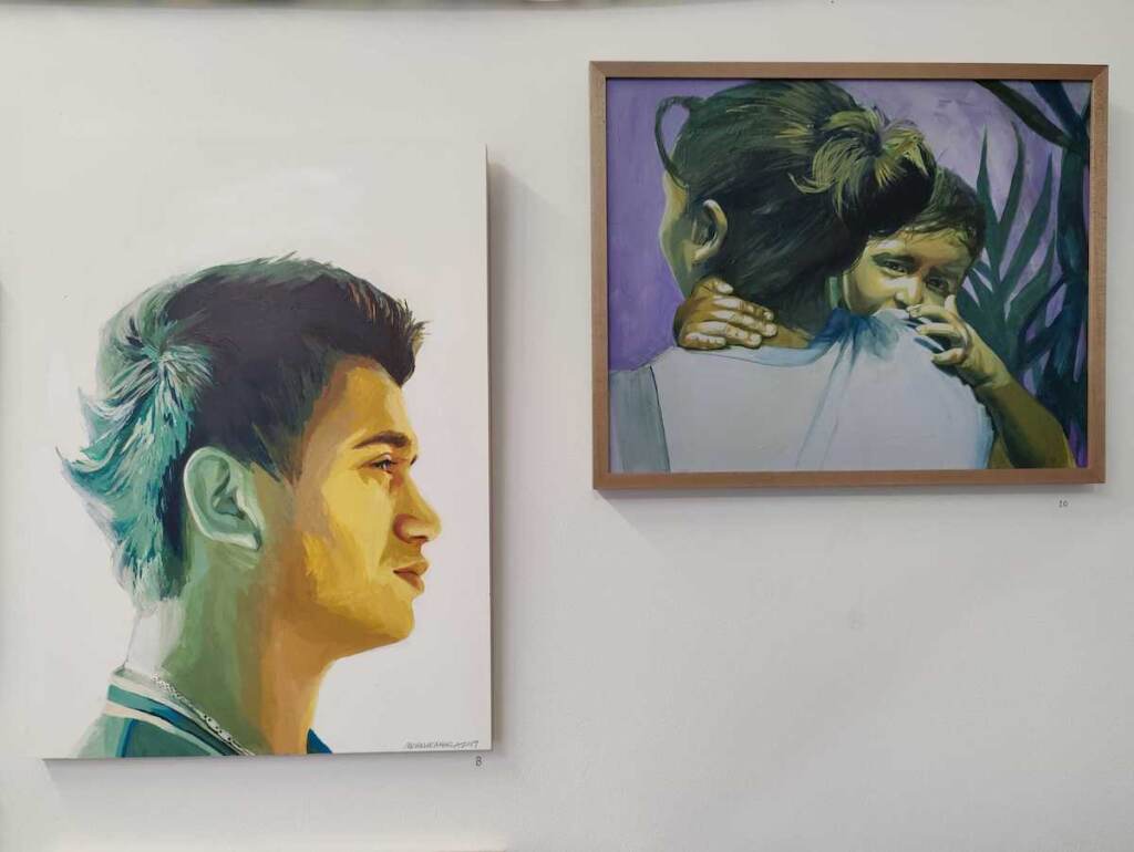 Paintings of people hung on a wall.