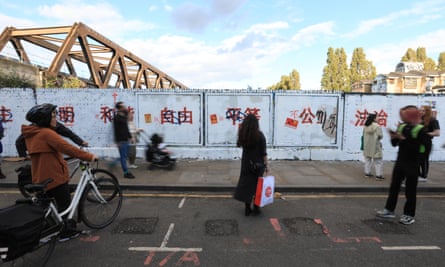 People in Brick Lane by a wall with Chinese characters in red
