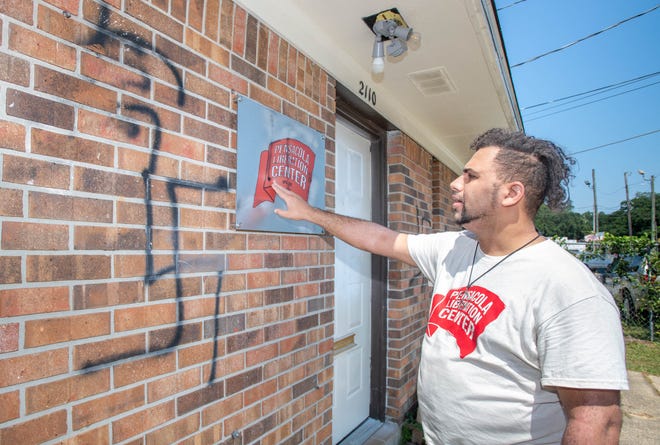 Honor Bell III explains that they have already started removing the Nazi symbols painted on the Pensacola Liberation Center on West Yonge Street in Pensacola on Friday, Aug. 4, 2023. The overnight graffiti is the latest anti-Semitic vandalism in the Pensacola area.