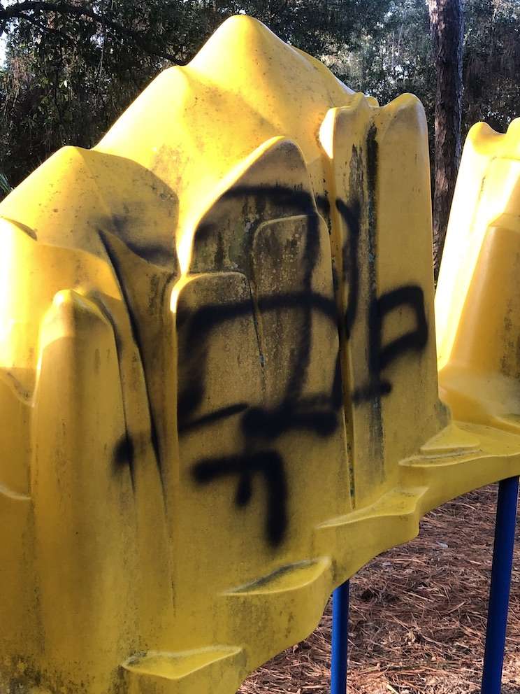 A yellow piece of playground equipment with a swastika on it in a Largo park.