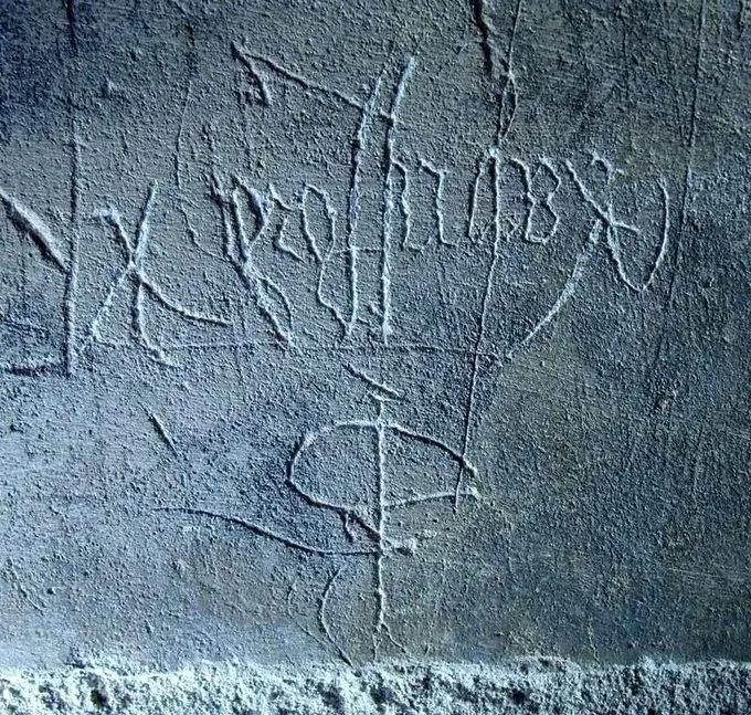 The name Keynsford scratched on the wall, upside down and back to front, as a curse.