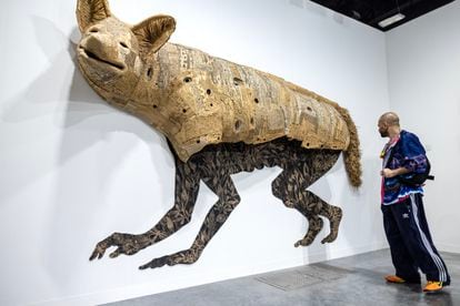 A visitor to Art Basel Miami Beach, in front of the piece 'Coyota/e,' by Hector Dionicio Mendoza, on Wednesday, December 6, 2023.