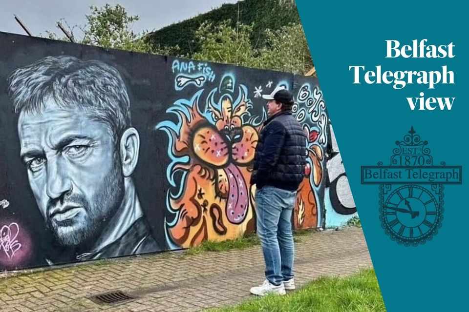 Hollywood star Gerard Butler inspects the painting of him in Bangor by Johnny Hamilton