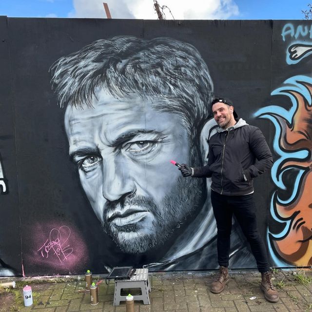 Johnny Hamilton pictured with the mural in Bangor