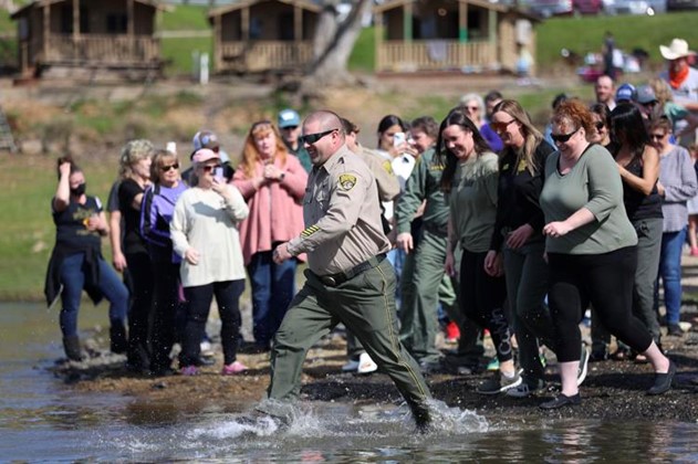 Sierra Conservation Center warden runs into the lake for the Polar Plunge for Special Olympics.